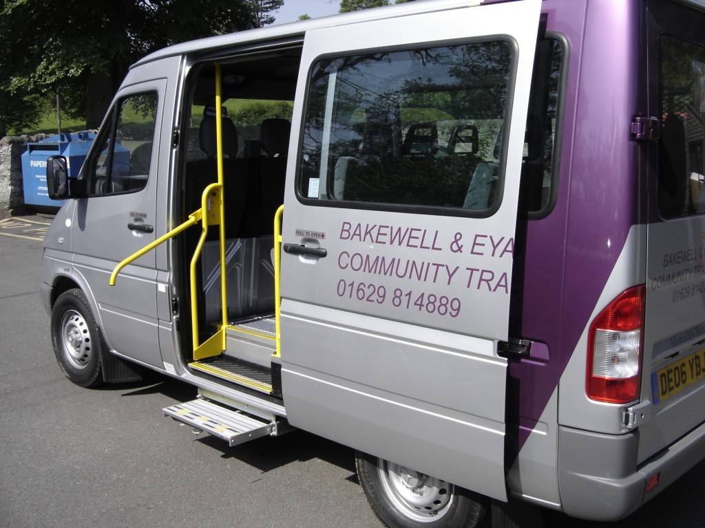 A grey minibus with Bakewell and Eyam Community Transport written on it.